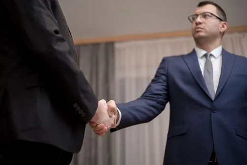 Business professionals shaking hands in an office meeting